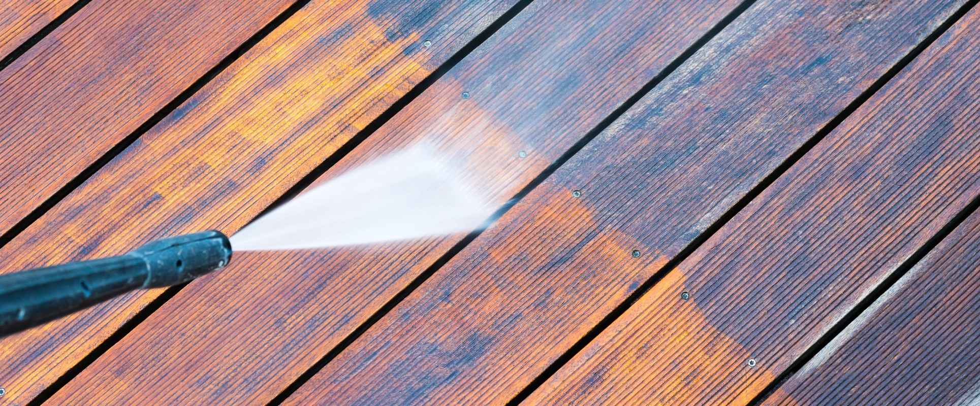 Pressure washer cleaning a wooden deck and patio Cleaning